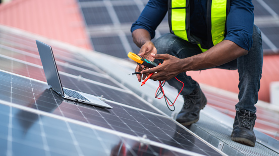 Service engineer checking solar cell on the roof for maintenance if there is a damaged part. Engineer worker install solar panel. Clean energy concept.